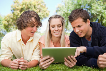 Three students using a touch pad