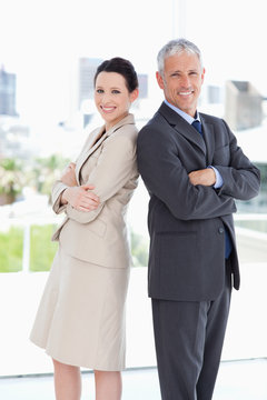 Smiling business people looking at the camera while standing upr