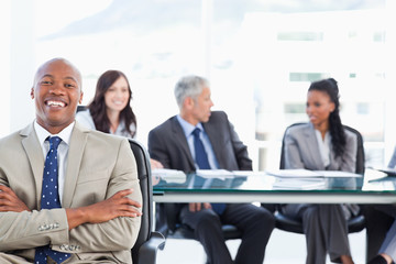 Young executive crossing his arms while laughing in front of the