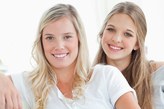 A pair of girls smiling as they look at the camera