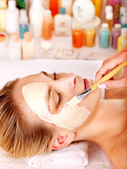 Clay facial mask in beauty spa.