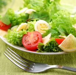 Fresh salad with tomato and quail eggs.