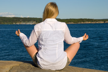 Frau beim Meditieren am Meer