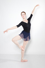 Fototapeta na wymiar Young beautiful dancer posing on a studio
