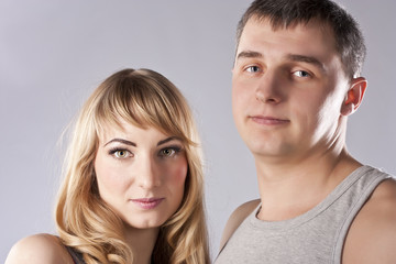 Young couple together on grey background