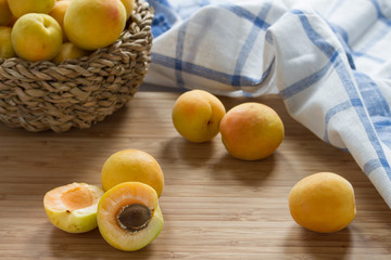 Apricots in wicker basket on wooden table