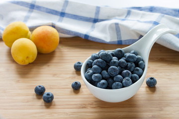 Blueberry and apricots on wooden table