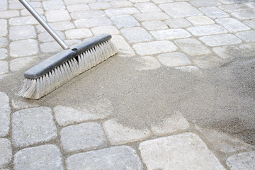 Broom Sweeping Sand into Pavers - 43116724