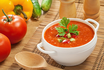 Gazpacho and ingredients on a table, vegetable soup