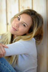 Naklejka premium Portrait of beautiful blond woman sitting on the floor