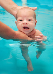 Fototapeta na wymiar little baby swimming in water