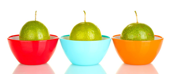 three green passion fruit in bowls isolated on white