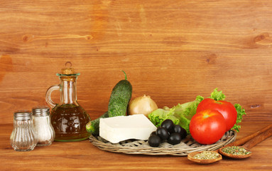 Ingredients for a Greek salad on wooden background close-up