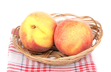 ripe peaches in basket isolated on white.