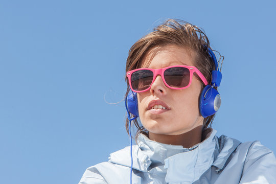 Girl listening to music with pink sun glasses