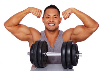 Portrait of smiling man in grey shirt with dumbbells