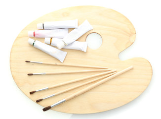 wooden art palette, tubes with paint and brushes isolated