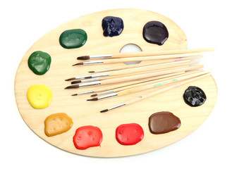 wooden art palette with  paint and brushes.isolated on white