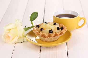 sweet cake with cup of tea on wooden background