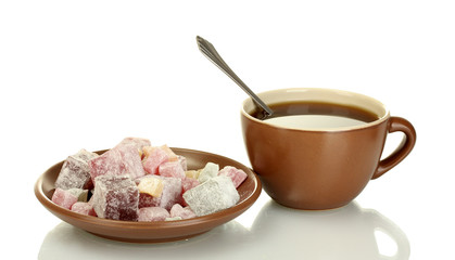 A cup of tea and saucer with delicious turkish delight isolated