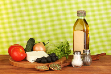 Ingredients for a Greek salad on green cloth background