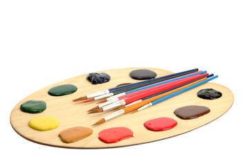 wooden art palette with  paint and brushes.isolated on white