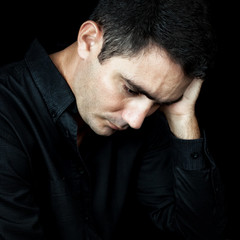 Fototapeta premium Worried and depressed man isolated on black