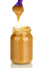 Jar with baby food and spoon on white background close-up