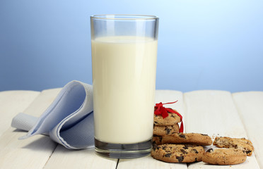 glass of milk and chocolate chips cookies with red ribbon