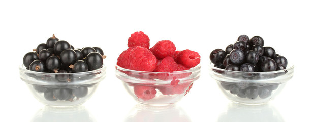 Fresh berries in transparent bowls isolated on white
