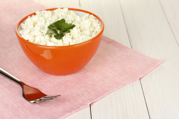 cottage cheese with parsley in orange bowl and fork