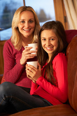 Portrait Of Mother And Daughter Relaxing On Sofa Together With H