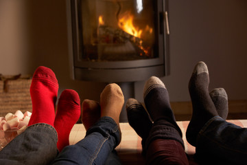 Close Up Of Familys Feet Relaxing By Cosy Log Fire With Marshmal