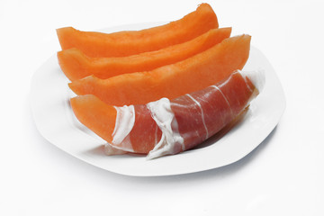 fette di melone con prosciutto su piatto_sfondo bianco