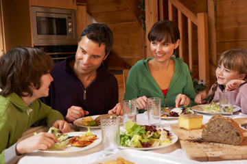 Family Enjoying Meal In Alpine Chalet Together