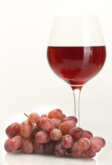 glass of wine and ripe grapes isolated on white