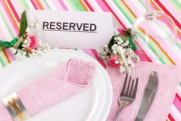 Table setting with reserved card in restaurant