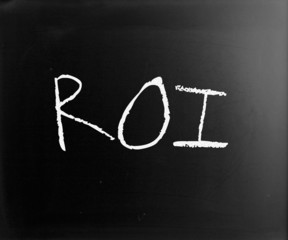 The word "ROI" handwritten with white chalk on a blackboard