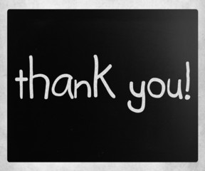 "Thank you" handwritten with white chalk on a blackboard