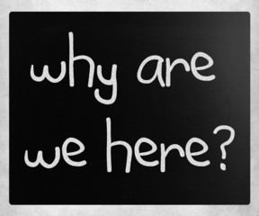 "why are we here" handwritten with white chalk on a blackboard