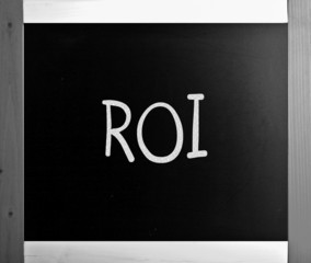 The word "ROI" handwritten with white chalk on a blackboard