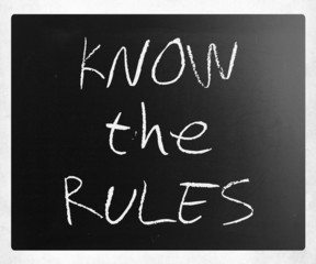 "Know the rules" handwritten with white chalk on a blackboard