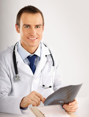 Doctor looking at x-ray on white background