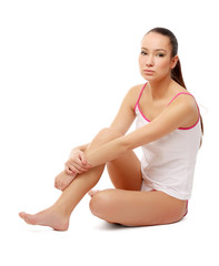A woman sitting on a floor, isolated on white background