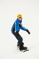 Fototapeta na wymiar Chłopiec Snowboard w dół zbocza na wakacje w Góry