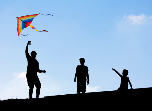 Launching a kite in the sky. Silhouettes man and two children.