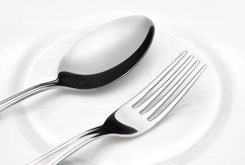 Flatware. Spoon and fork on a plate