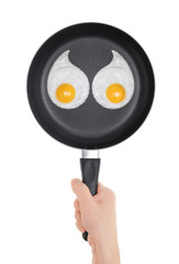 Fried eggs in the form of a woman's breasts. Pan in hand on whit