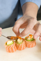 Suchi chef preparing salmon rolls