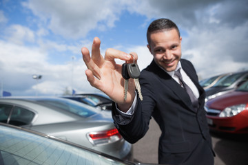 Happy dealer holding car keys